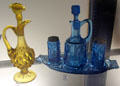 Yellow pressed glass cruet with fist stopper from Pittsburgh, PA & blue pressed glass cruet set by Bellaire Goblet Co. of Bellaire, OH at Bennington Museum. Bennington, VT.