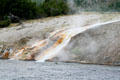 Waterfall from Excelsior Geyser flows into Firehole River at Yellowstone National Park. WY.