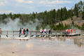 Visitors on raised walkway above Excelsior Geyser of Yellowstone National Park. WY.