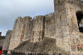 Massive defensive walls with arrow slits at Caernarfon Castle. Caernarfon, Wales.