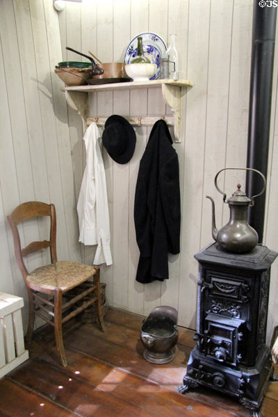 Small stove, wooden chair & coat rack at Van Gogh House in Cuesmes. Mons, Belgium.
