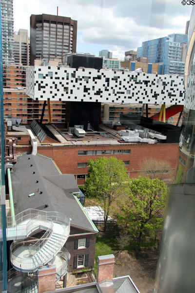 OCAD University's black & white "tabletop" structure standing on poles over Grange heritage original building of Art Gallery of Ontario with its spiral staircase. Toronto, ON.