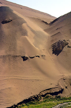 Colorful sands cover mountains along road to Bezeklik Caves, Turpan. China.