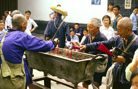 Monks lighting incense in Chengdu. China.