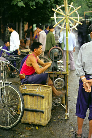 Man working on a sewing machine in Chengdu. China.