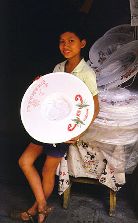 Boy selling flexible hats in Guangzhou. China.