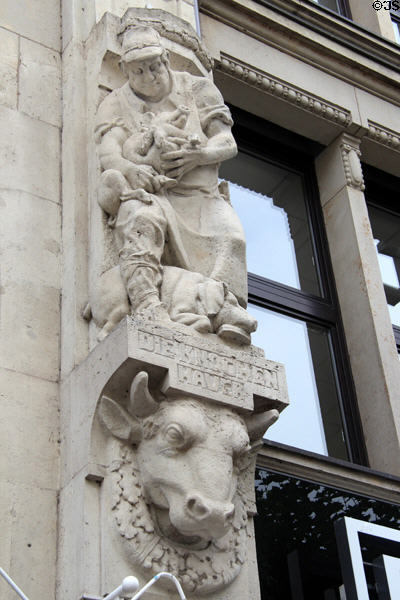 Versmann-Haus (1910-12) carvings of aproned man holding pigs on City Hall Market square. Hamburg, Germany. Architect: Johann Gottlieb Rambatz & Wilhelm Jollasse.