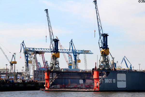 Elbe River shipyard with floating drydock & cranes. Hamburg, Germany.