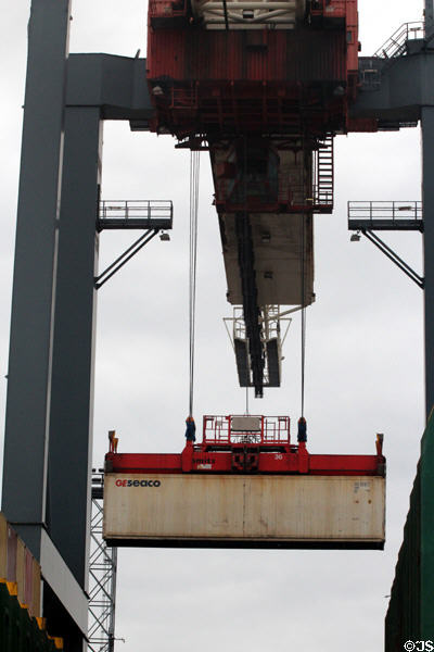 Crane carrying container at container port. Hamburg, Germany.