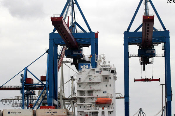 Cranes moving cargo on container ship at container port. Hamburg, Germany.