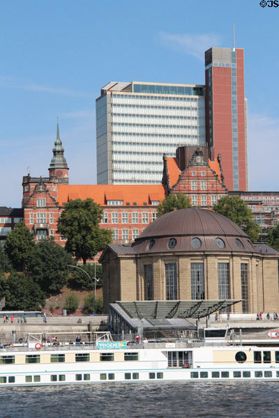 Red tower of Atlantic-Haus (2006) above Brown dome of Alter Elbtunnel at St Pauli Pier. Hamburg, Germany. Architect: gmp Architekten; Herzog + Partner.