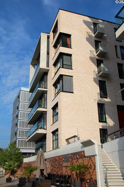 Modern buildings above decorative brickwork flood barrier wall on Dalmannkai in HafenCity. Hamburg, Germany.