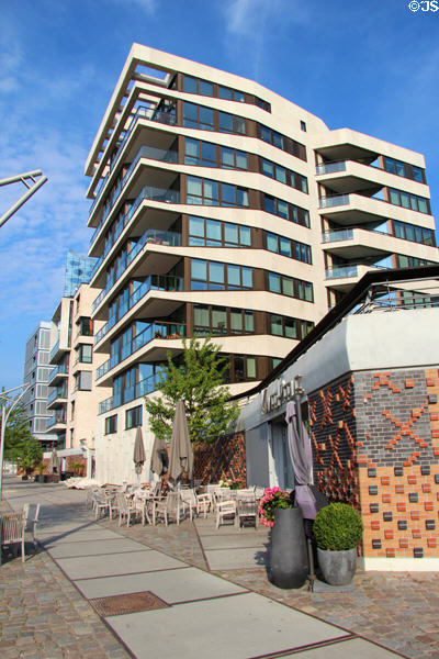 Modern buildings above decorative brickwork flood barrier wall on Dalmannkai in HafenCity. Hamburg, Germany.