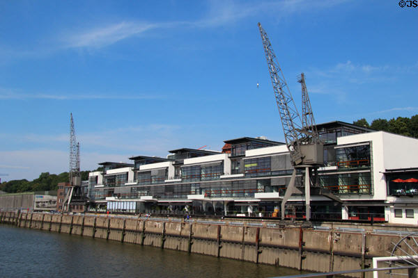 Antique cranes kept as highlight to modern buildings along Elbe River. Hamburg, Germany.