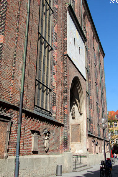Southern side door with sundial & monument plaques of Frauenkirche. Munich, Germany.