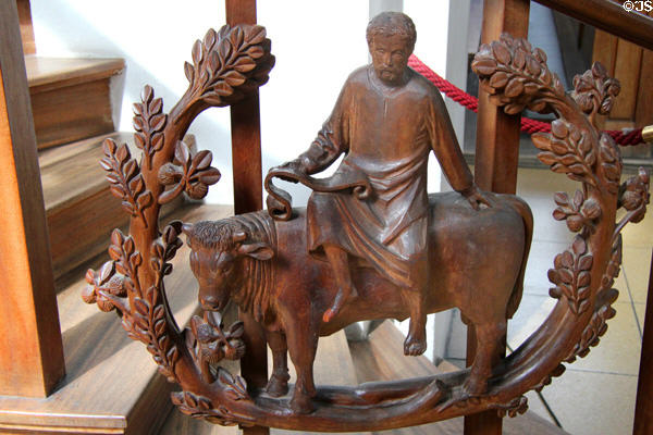 Modern pulpit carving of Evangelist St Luke with bull symbol at Heilig-Geist-Kirche. Munich, Germany.