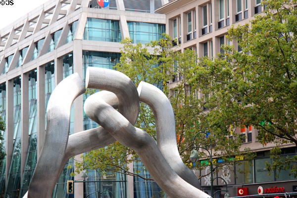 Broken chain sculpture (1987) by Brigitte Matschinsky-Denninghoff & Martin Matschinsky on Ku'dam with Peek & Cloppenburg store. Berlin, Germany.
