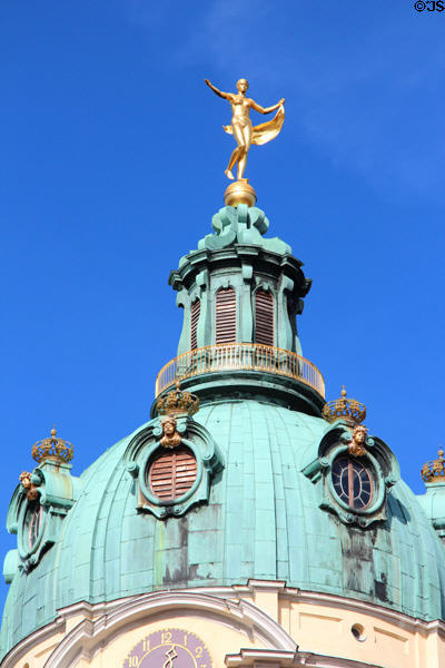 Golden statue atop baroque tower dome at Charlottenberg Palace. Berlin, Germany.