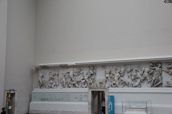 Frieze carving originally around exterior perimeter of Pergamon altar now displayed on interior museum walls in front of the ancient structure (c170 BCE) at Pergamon Museum. Berlin, Germany.