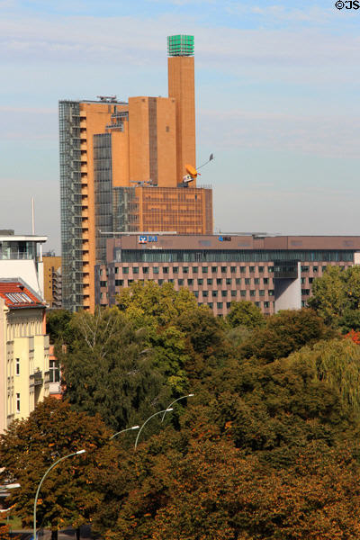 Commercial buildings marked by tower topped by green cube over Karlsbad Park. Berlin, Germany.