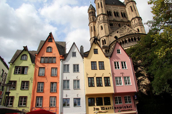 Colorful restored historic dwellings of Fischmarkt area with tower of Great St Martin church in background. Köln, Germany.