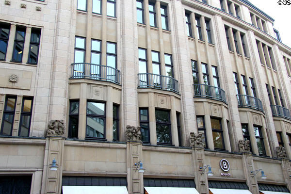 Building decorated with human figures engaged in clothing trade activities. Köln, Germany.