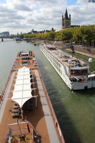 Busy Rhine River traffic seen from Hohenzollern Bridge with tour boat & barge in foreground. Köln, Germany.