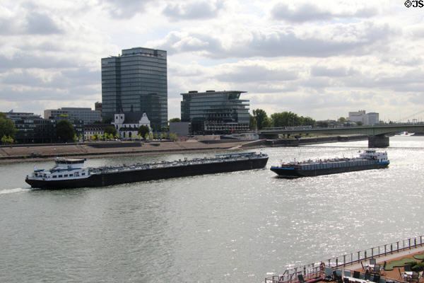 Barge traffic on Rhine River with modern buildings on east bank. Köln, Germany.