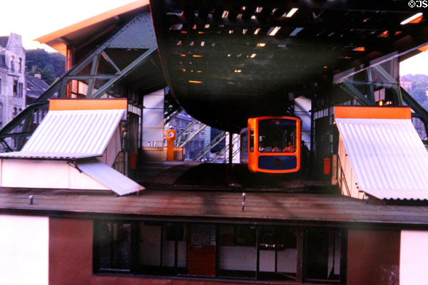 Hanging monorail exits station. Wupperthal, Germany.