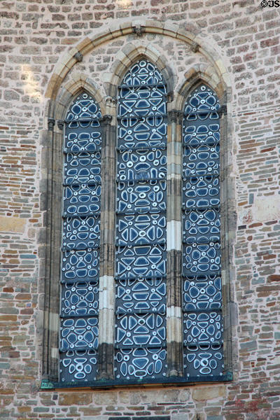Window inset into rough brick wall of Palatine Chapel at Aachen Cathedral. Aachen, Germany.