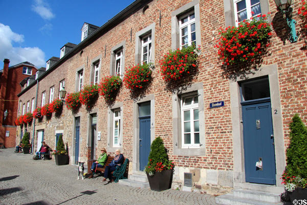 Brick row houses with flowers on Domhof at Aachen Cathedral. Aachen, Germany.