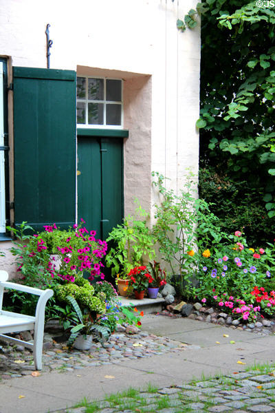 Flowers before doorway at Füchtings Courtyard. Lübeck, Germany.