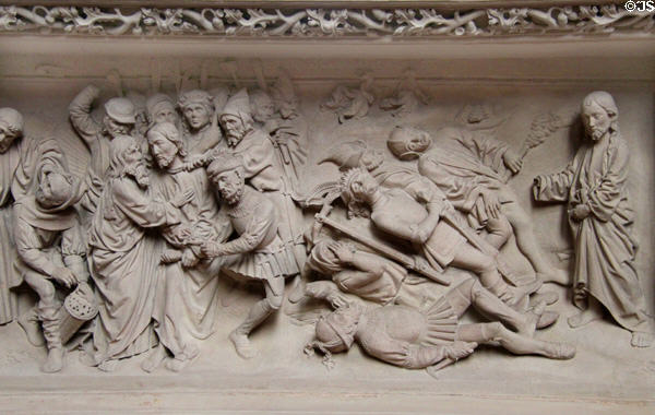 Stone carved religious scene with figures in Medieval dress at St Mary's Church. Lübeck, Germany.