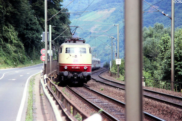Electrified train traveling along bank of Rhine River. Germany.