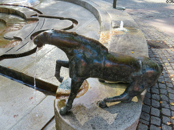 Horse marking the hour in Water Clock Fountain beside Red Tower. Trier, Germany.