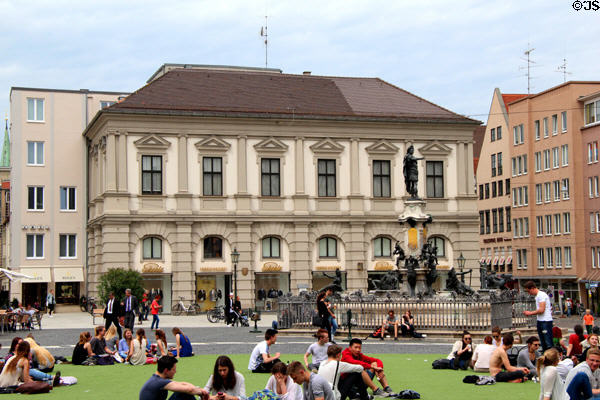 People relaxing around Augustusbrunnen fountain. Augsburg, Germany.