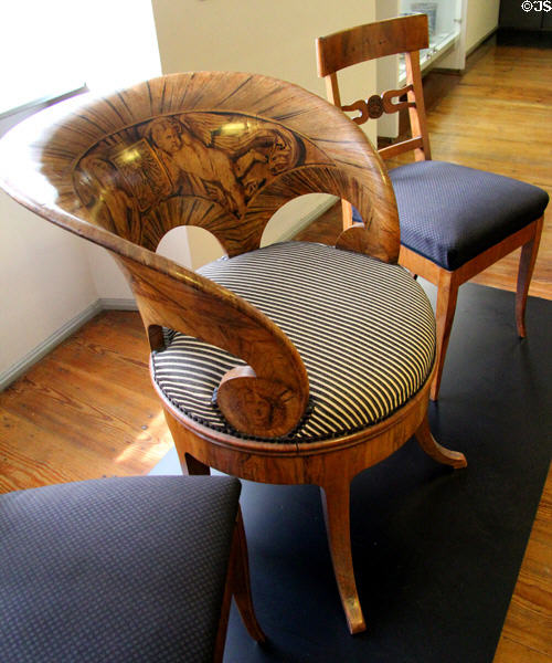 Round mayor's armchair with inlaid putti of walnut veneer (c1830) at Fembohaus City Museum. Nuremberg, Germany.