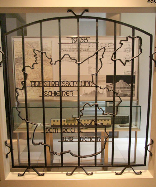 Ornamental iron grille (1938) with old German borders & Nazi slogan from Regensburg vehicle depot at Nuremberg Transport Museum. Nuremberg, Germany.