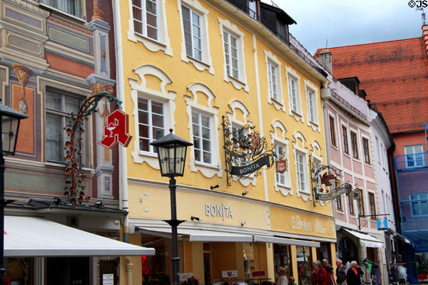 Buildings with ornate metal signs along Reichenstrasse pedestrian area. Füssen, Germany.