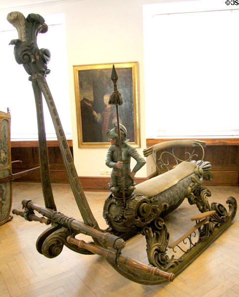 Carved lady's side-saddle horse-drawn racing snow sled with knight on prow at Lindau Municipal Museum. Lindau im Bodensee, Germany.
