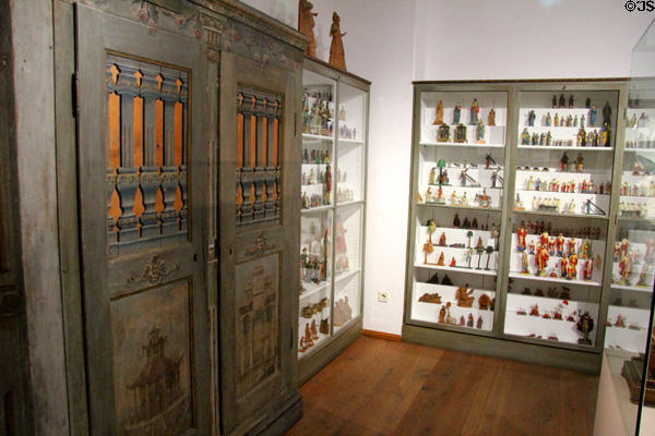 Painted Bavarian cabinet beside collection of carved religious figures, a specialty of the region, at Oberammergau Museum. Oberammergau, Germany.