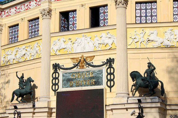 Equestrian riders flanking door of Cirque d'Hiver. Paris, France.