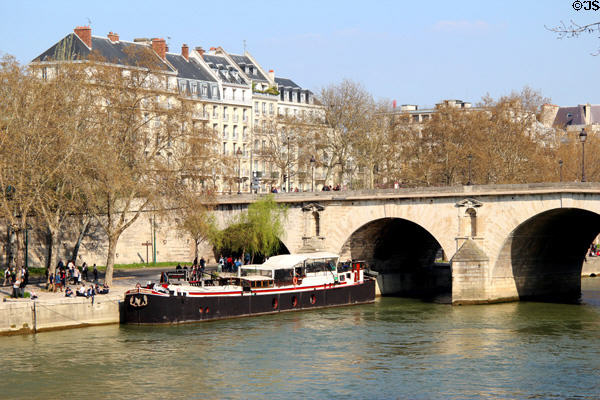 Stone arches of Pont Marie (17thC) & buildings of Quai des Célestins,. Paris, France.