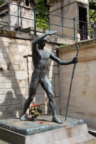 Tomb sculpted in form of walking man at Montmartre Cemetery. Paris, France.