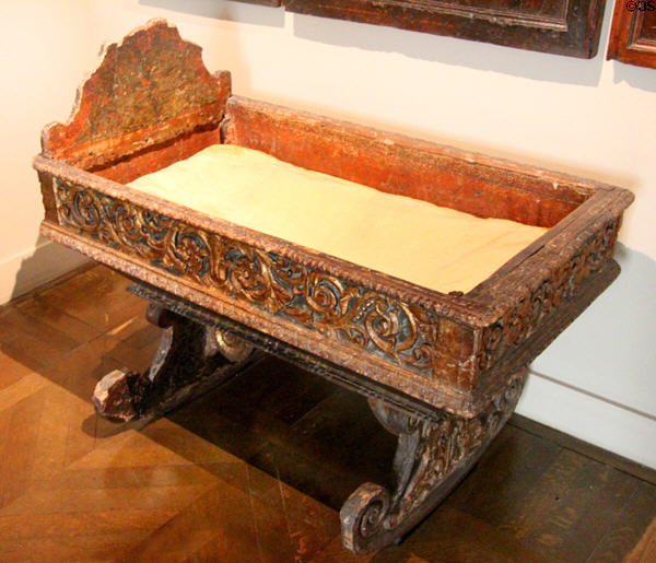 Rocking cradle with carved sides at Museum of Decorative Arts. Paris, France.