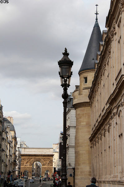 Rue Saint-Martin facade of corner tower of Arts et Metiers Museum with Porte Saint-Martin arch beyond. Paris, France.
