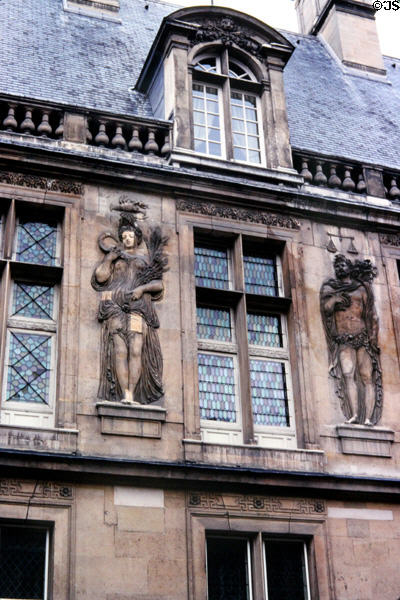 Human figure carvings on wall over courtyard at Carnavalet Museum. Paris, France.