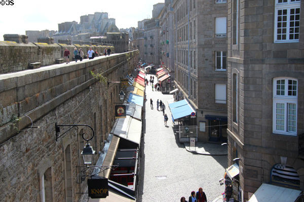 Visitors walking along ramparts above Rue Jacques Cartier. St Malo, France.