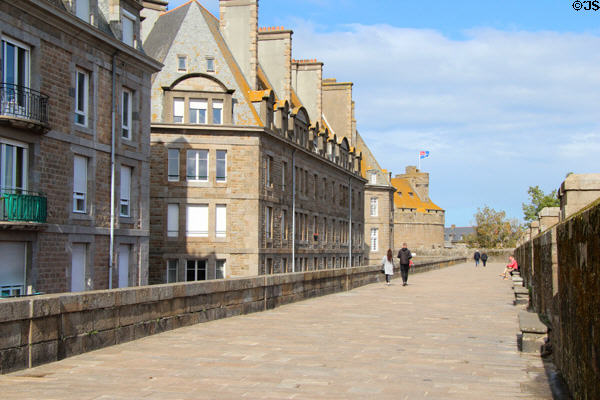 Visitors strolling along broad ramparts above Quai Saint-Vincent. St Malo, France.