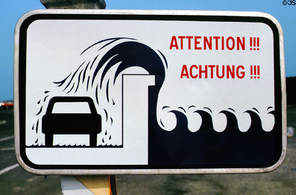 Sign warning of dangers of parking beside sea wall. St Malo, France.